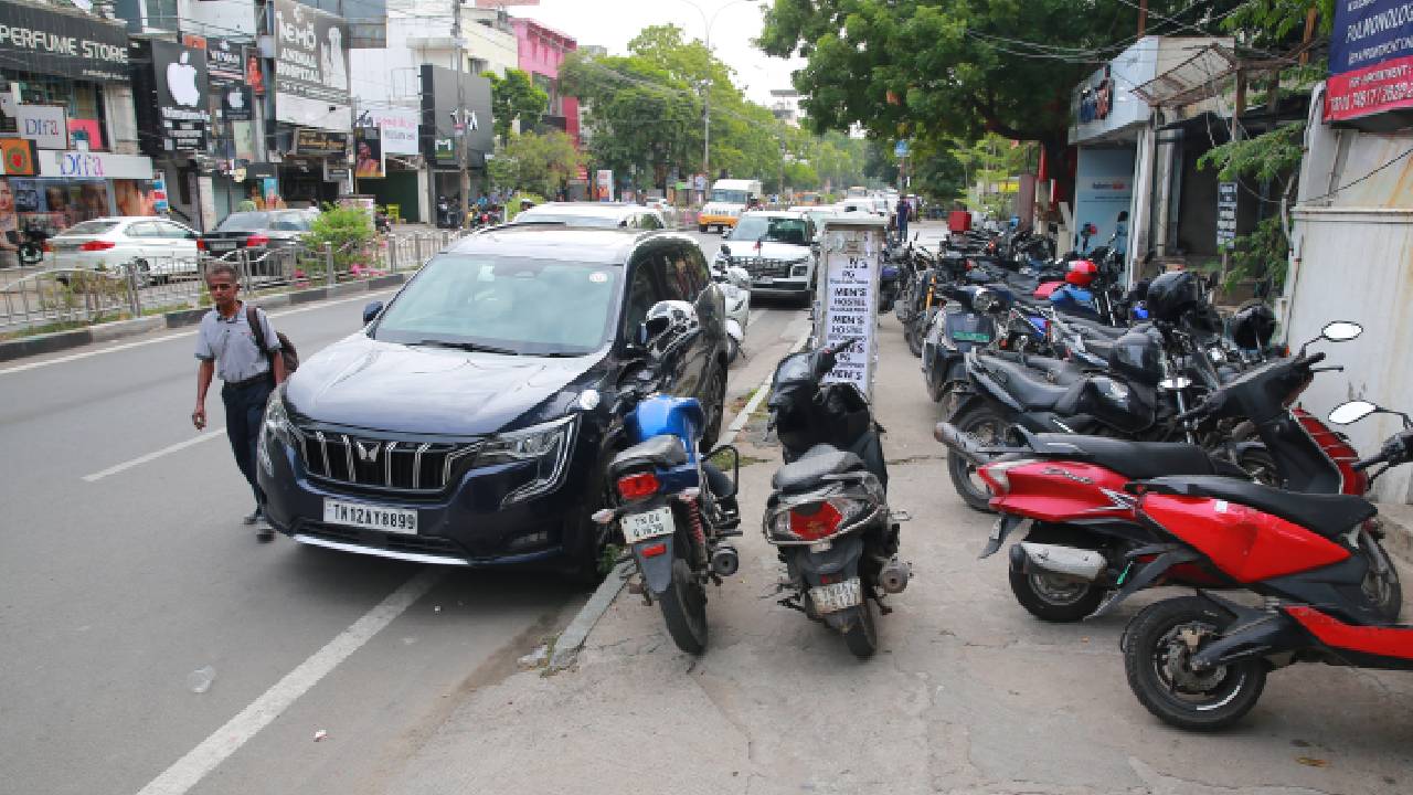 Vehicles parked on the footpath in front of RBL Bank on 4th Avenue Road in Chennai's Anna Nagar force pedestrians onto the road. (Sunish P Surendran)