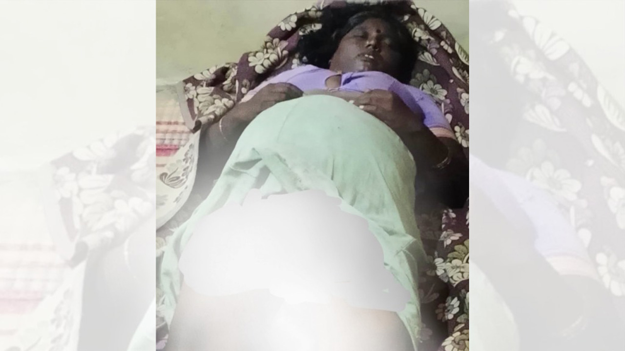 Photograph of Thenmozhi, a nine-month-pregnant Irular woman, lying on a bed with her abdomen covered by a cloth.
