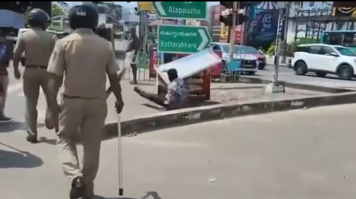 An unidentified man destroying the flex of Kodiyeri Balakrishnan during an SFI march in Kollam.