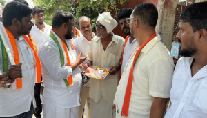 Congress workers campaign for TVK candidate Maragatham Kumaravel by speaking to a voter in Maduranthakam.