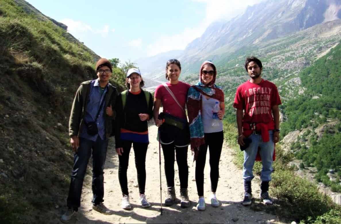 Two man and three woman standing in the path to Gangotri with high mountains on the back