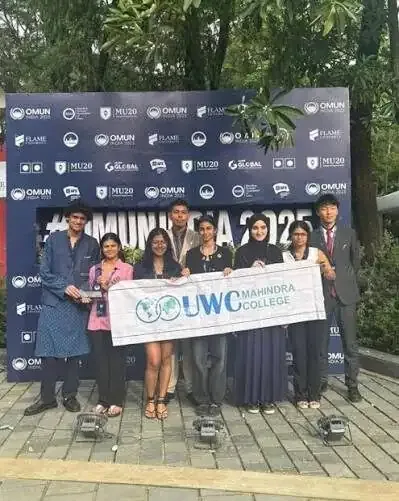 Students holding a UWC Mahindra banner at a conference