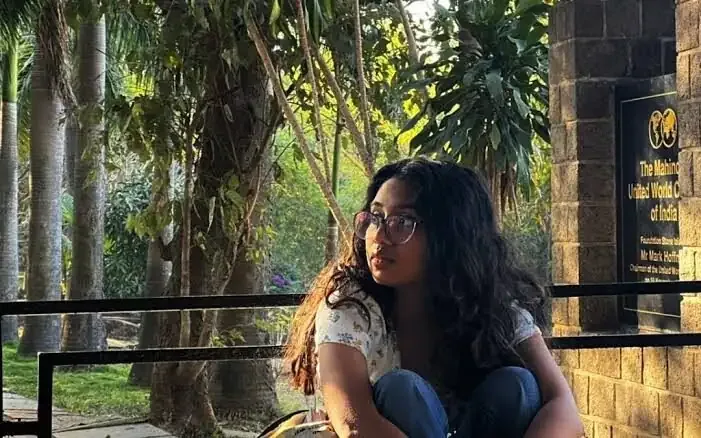 A student sitting beside the MUWCI foundation stone