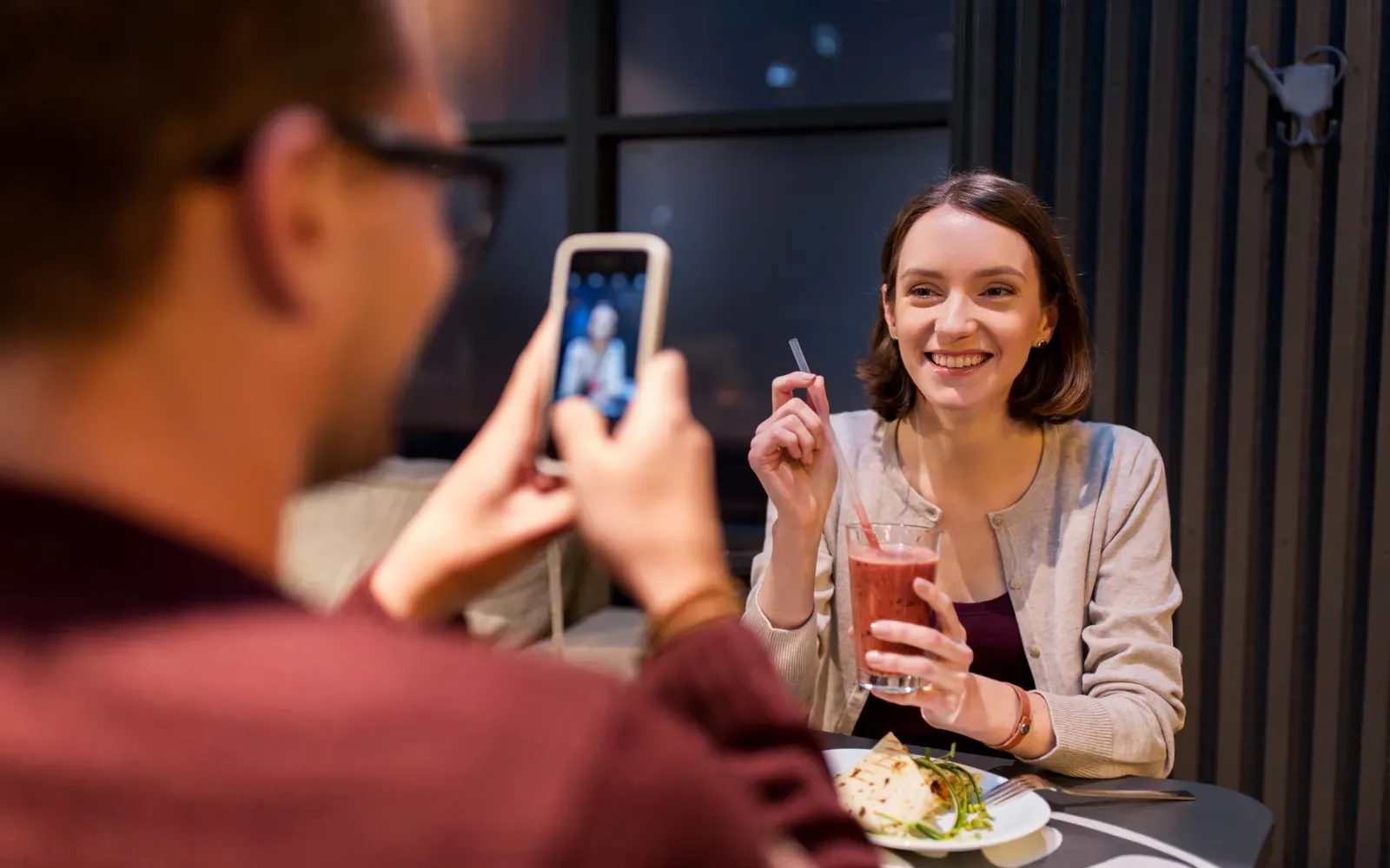 Customer photographing food with a phone in a restaurant
