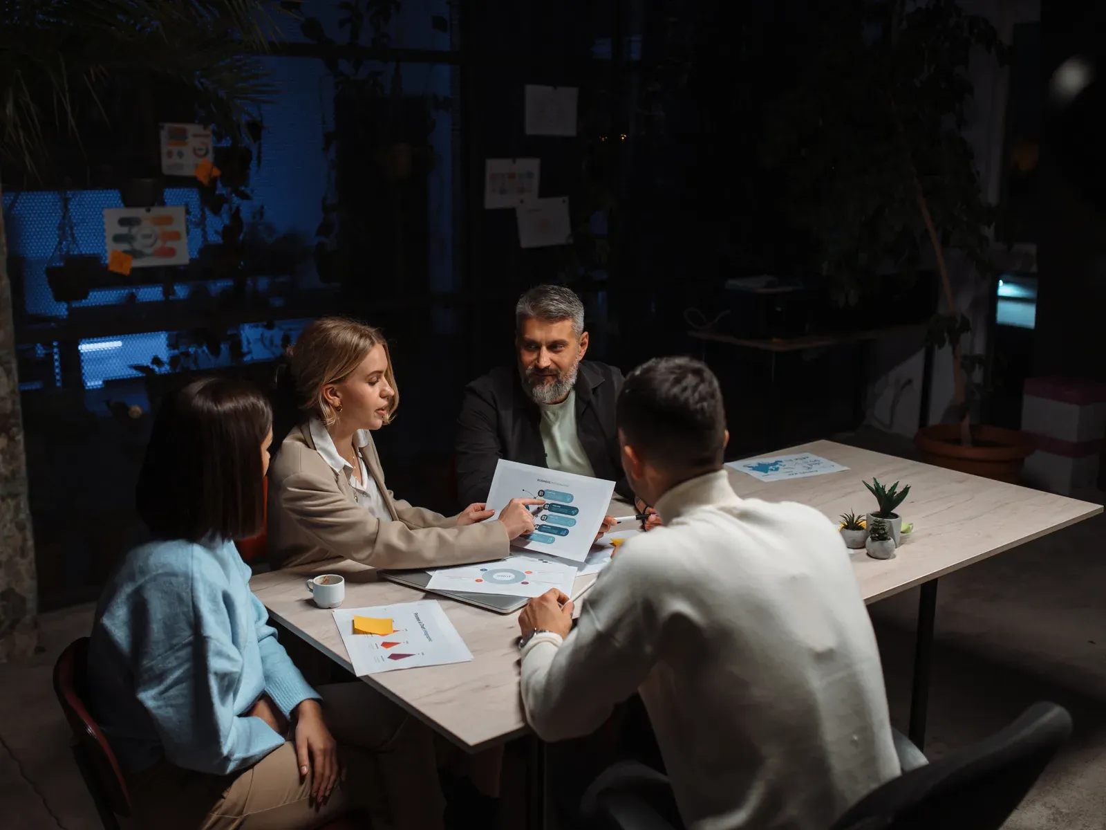 Team in discussion around a table in a contemporary evening office