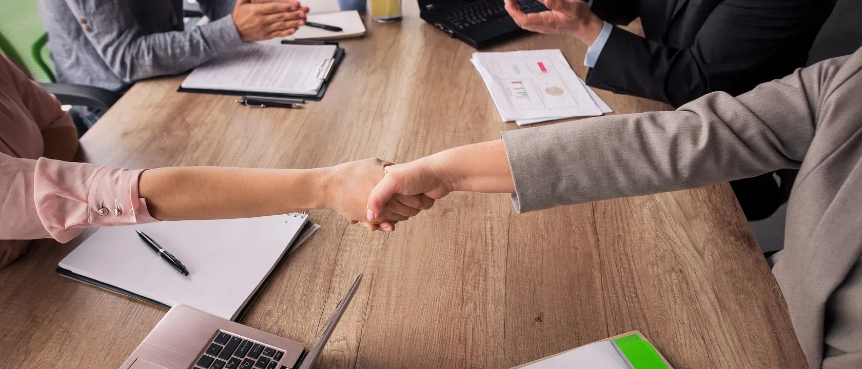 Two partner teams meeting across a boardroom table
