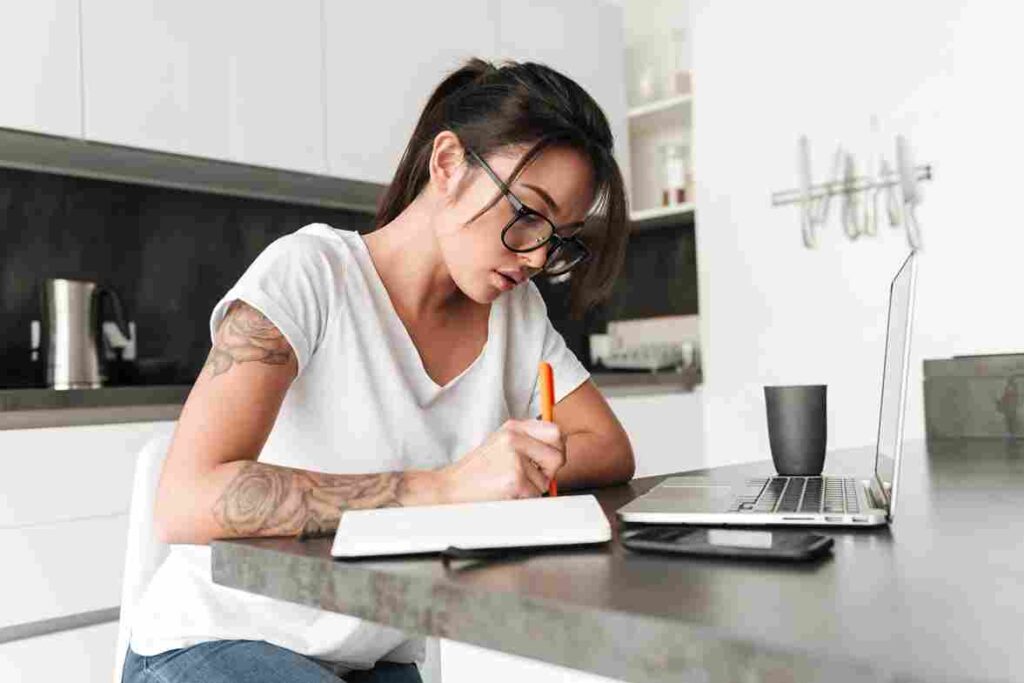 concentrated-serious-young-woman-using-laptop-computer-writing-notes-1_11zon.jpg