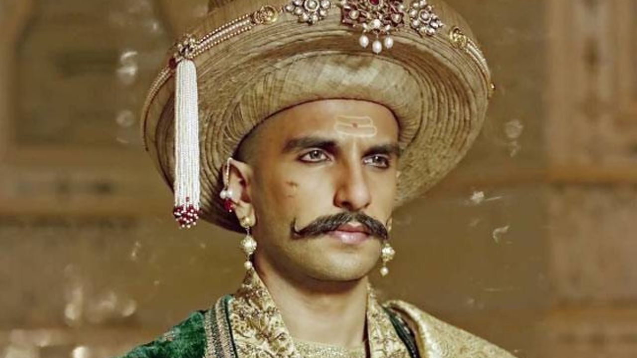 Peshwa Bajirao in Bajirao Mastani: For this historical character, Ranveer committed to a completely different look, including a shaved head (bald look) and a distinctive handlebar moustache, paired with traditional Maratha attire like heavy sherwanis and flared kurtas. Peshwa Bajirao in Bajirao Mastani: For this historical character, Ranveer committed to a completely different look, including a shaved head (bald look) and a distinctive handlebar moustache, paired with traditional Maratha attire like heavy sherwanis and flared kurtas.