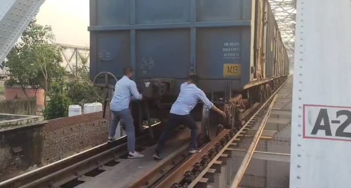तकनीकी टीम मालगाड़ी के डिब्बों की जांच करते हुए 