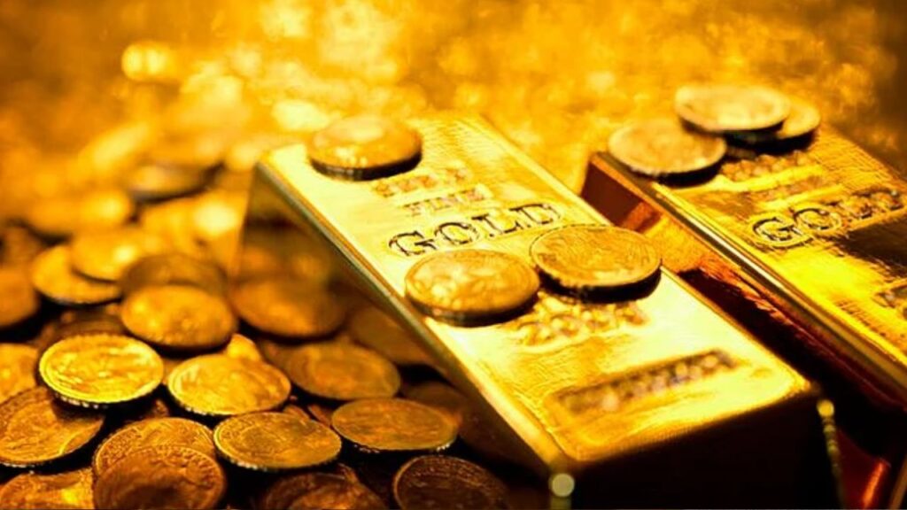 Gold coins and bars with red downward trend arrow showing price fall