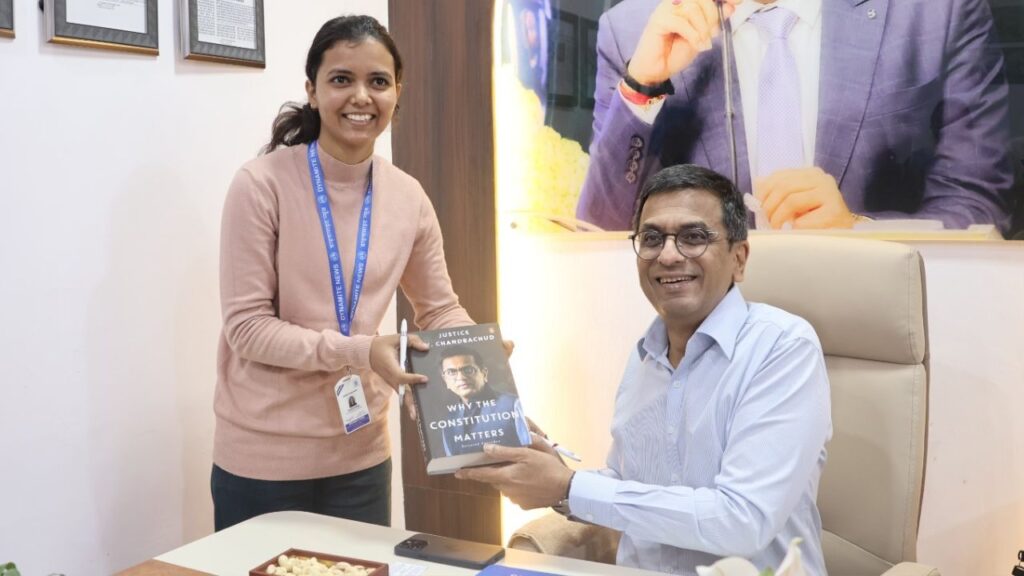 Dr Chandrachud presents his autographed book 'Why the Constitution Matters' to Sub-Editor Saumya Singh
