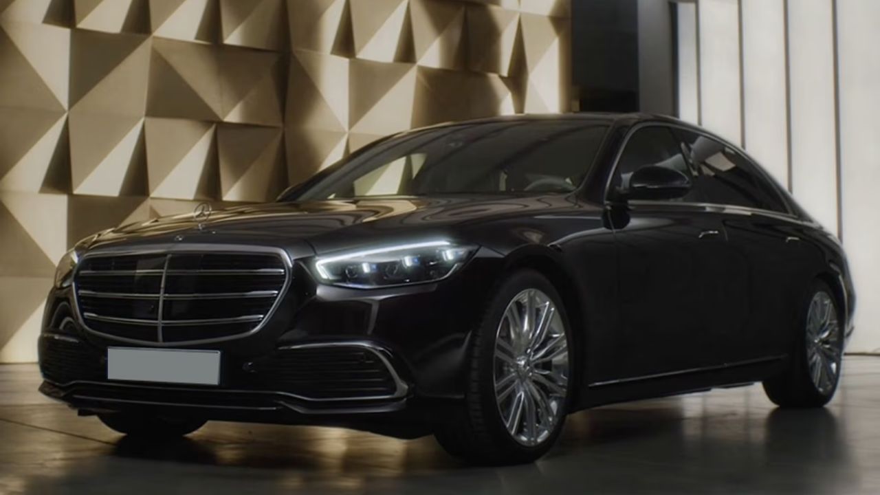 नई Mercedes-Benz S-Class पहले से ज्यादा शाही और दमदार रोड प्रेजेंस के साथ आती है। इसकी फ्रंट ग्रिल को करीब 20 प्रतिशत बड़ा किया गया है और अब यह इल्यूमिनेटेड भी है। ग्रिल में 3D क्रोम स्टार एलिमेंट्स दिए गए हैं, जो इसे बेहद प्रीमियम लुक देते हैं। बोनट पर लगा आइकॉनिक Mercedes स्टार भी रोशन होता है, जिससे रात के समय कार और ज्यादा आकर्षक नजर आती है। (Img- Internet)