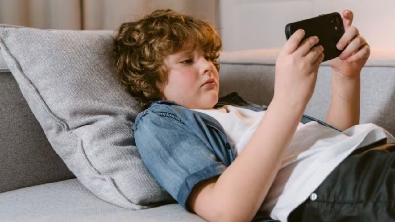 आजकल माता-पिता बच्चों को चुप कराने या व्यस्त रखने के लिए मोबाइल थमा देते हैं, लेकिन यह आदत आगे चलकर भारी पड़ सकती है। नई रिसर्च बताती है कि 12 साल से कम उम्र में स्मार्टफोन मिलने से बच्चों के मानसिक और शारीरिक विकास पर नकारात्मक असर पड़ता है, जिसे अक्सर नजरअंदाज कर दिया जाता है। (फोटो सोर्स- इंटरनेट)
