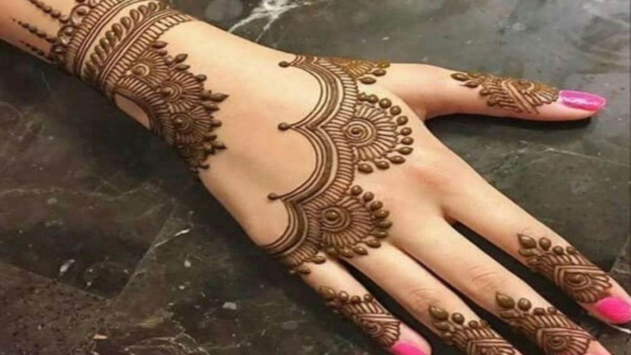 बैक हैंड के लिए यह डिजाइन उन लोगों के लिए है जो चाहते हैं कि मेहंदी जल्दी लगे और रंग भी गहरा आए। सबसे पहले हाथ के बीच में फ्लावर बनाएं और उसमें शेडिंग करें। इसके बाद दूसरा हाफ फ्लावर बनाकर उसे डार्क आउटलाइन दें। कलाई और रिंग फिंगर की तरफ पत्तियों की बेल बनाएं।  