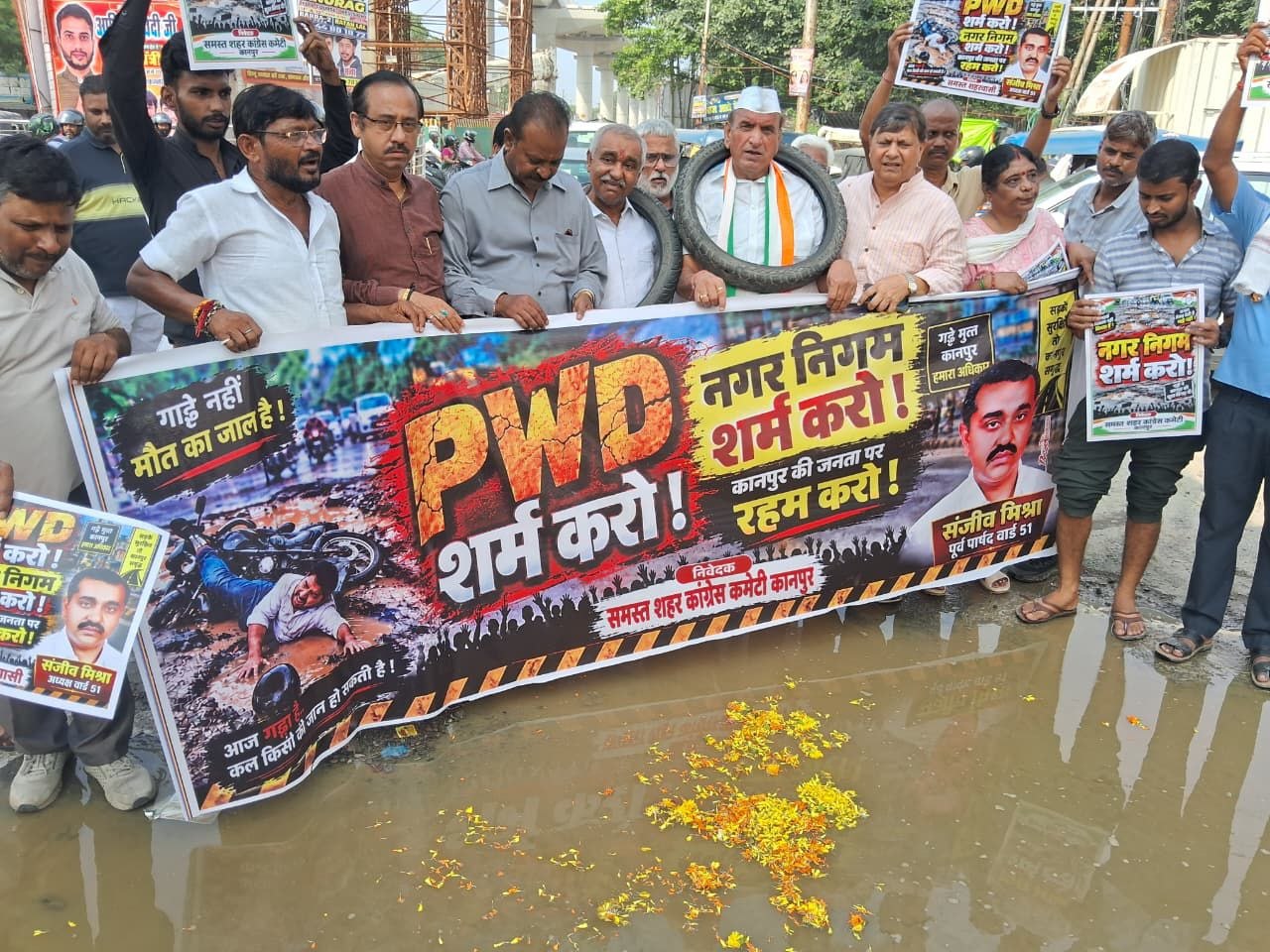 गले में टायर, गड्ढों में फूल और फिर रामधुन; कानपुर में सड़कों की बदहाली पर कांग्रेस का अनोखा प्रदर्शन
