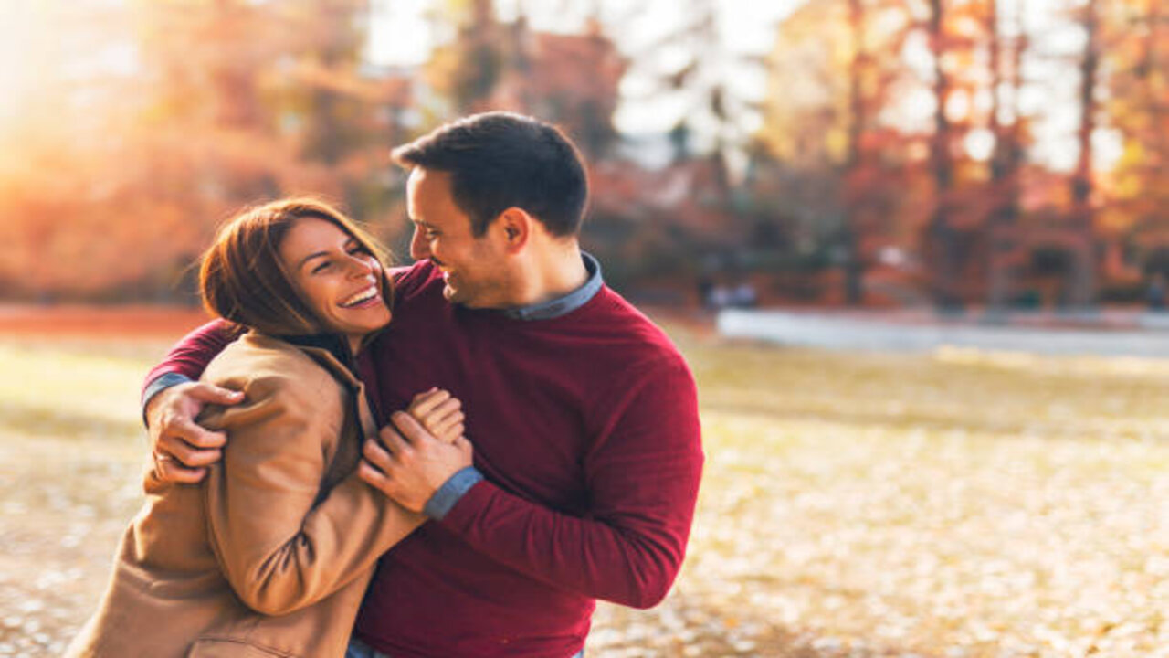 Couple In Love Hugging And Enjoying At Public Park In Autumn