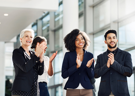 Happy employees clapping hands together