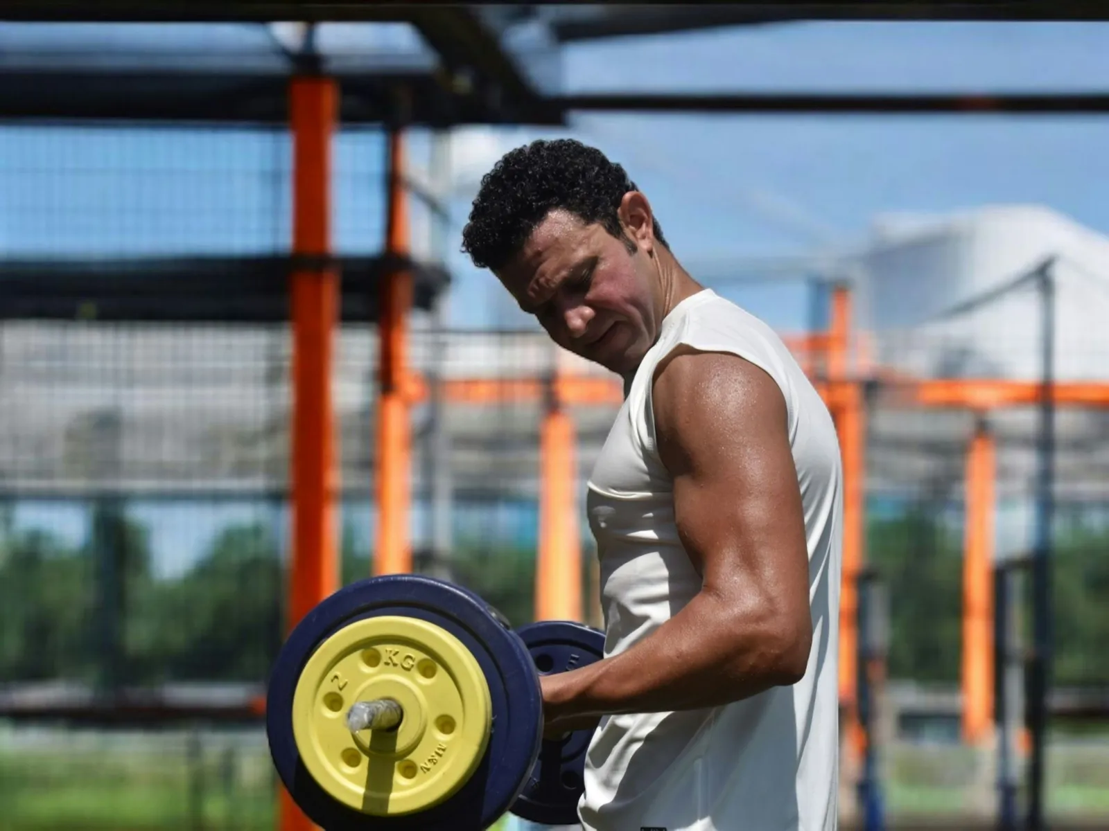 Man lifts a dumbbell outdoors